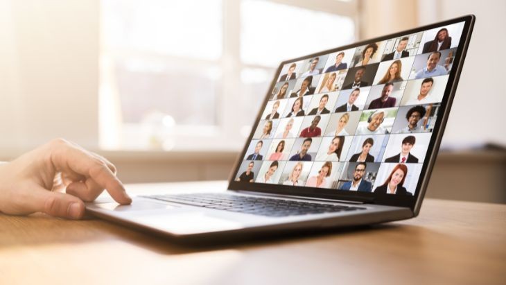 Laptop showing a webinar with several participants on screen.